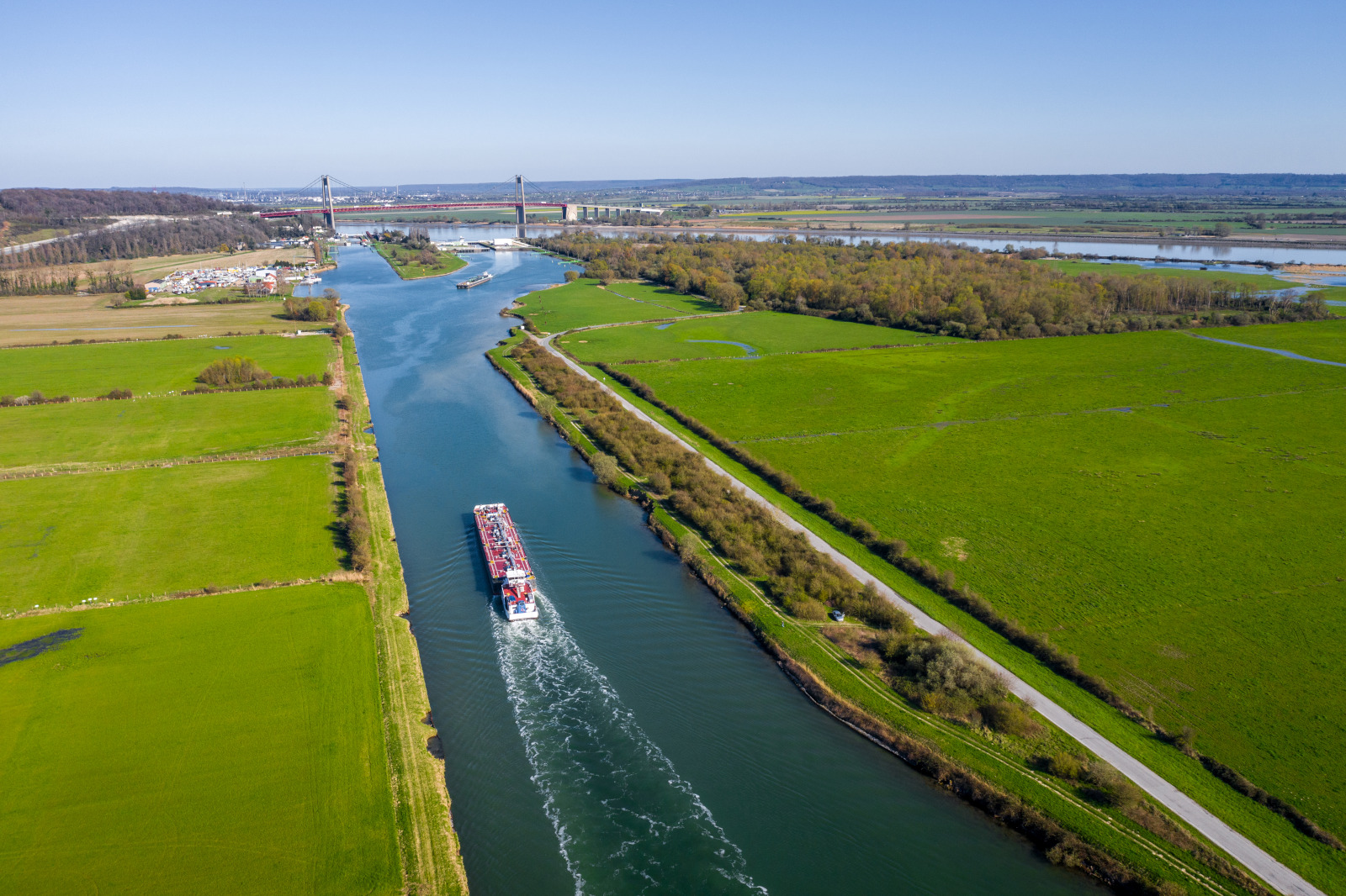 vue aérienne du canal de Tancarville. Navigation d'une barge fluviale.