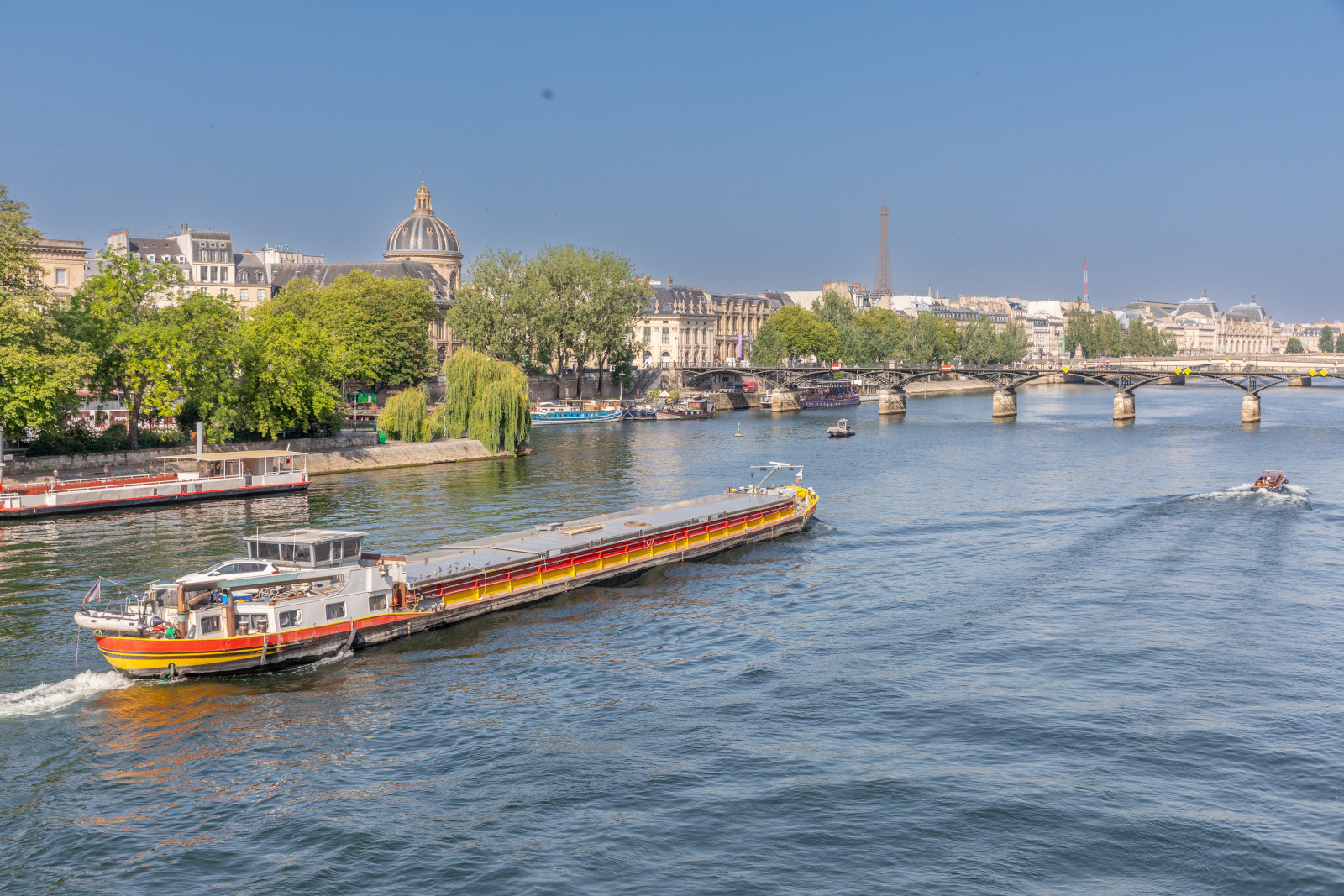 Barge fluviale en navigation sur la Seine à Paris. Passage devant le pont des Arts.