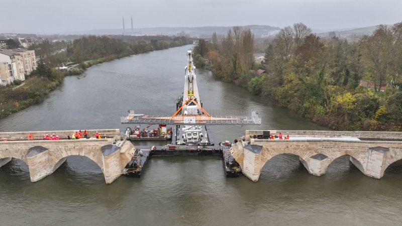 Pose de la passerelle devant relier l'Île-aux-Dames à Limay depuis une barge fluviale.