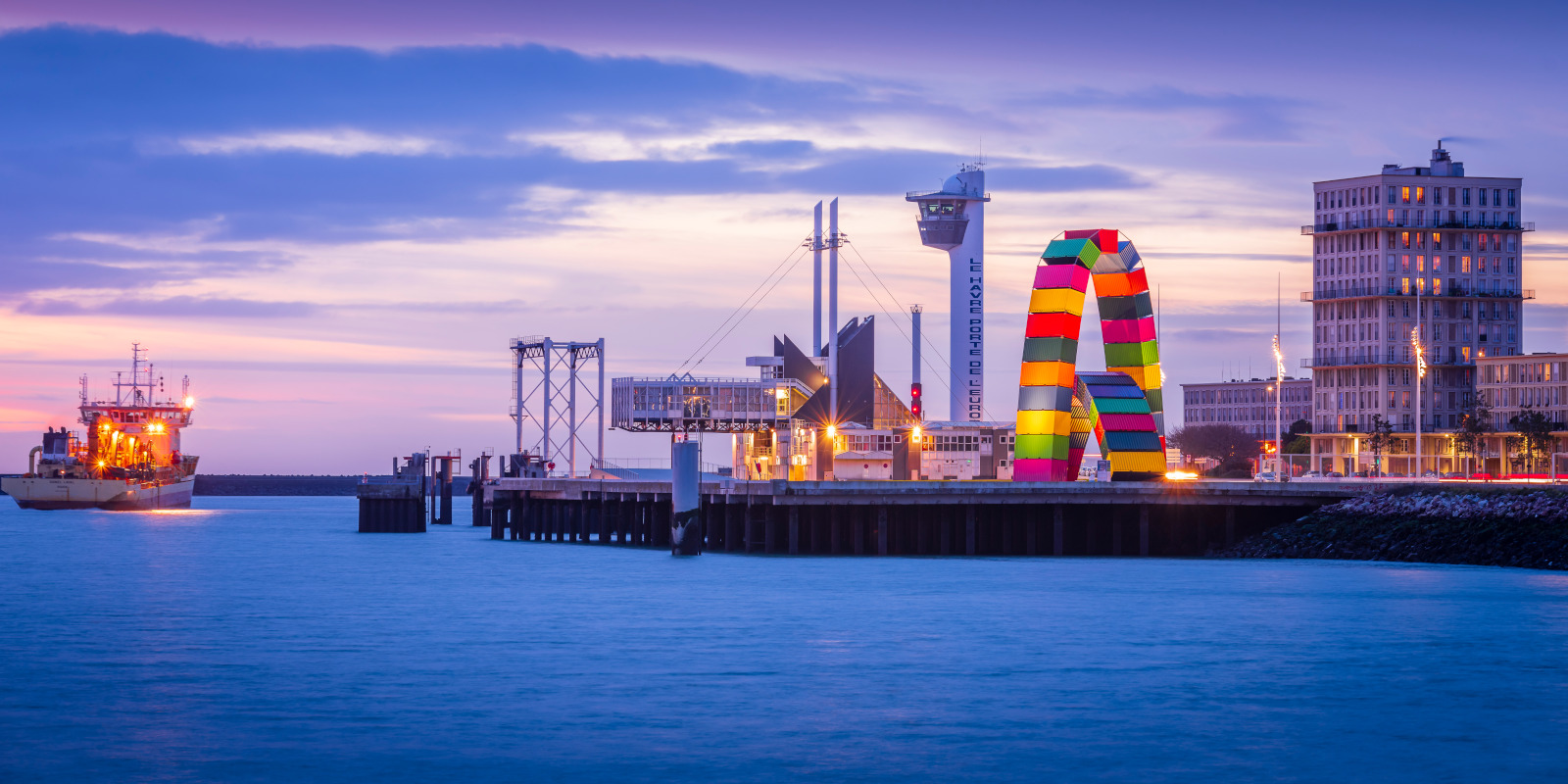 Vue sur la catène à conteneurs, capitainerie du Havre en arrière plan. Drague en activité