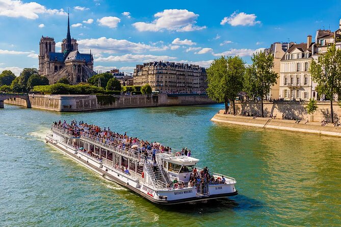 Péniche de la compagnie Bateaux Mouches naviguant sur la Seine, passant devant Notre Dame.